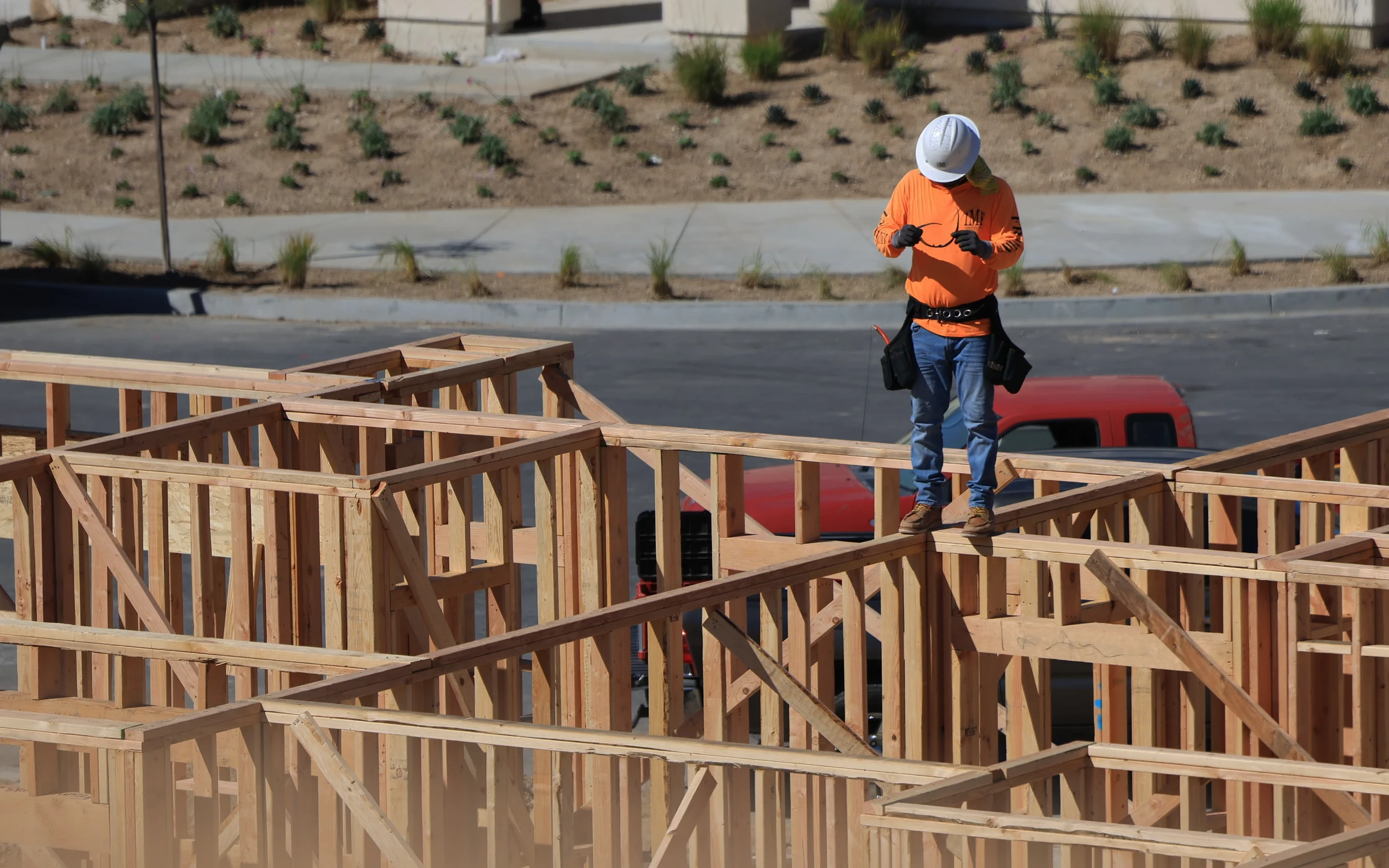 General contractor reviewing work on a framed residential jobsite